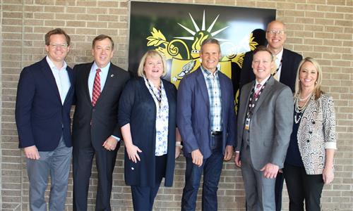 Board members, administrators and state leaders pose for a photo